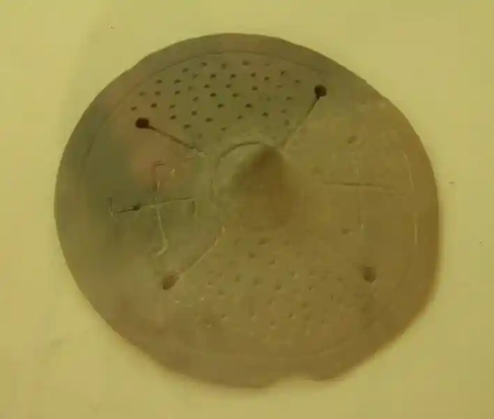Two swastikas on a circular clay figure